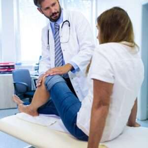 male doctor examining patients knee 1