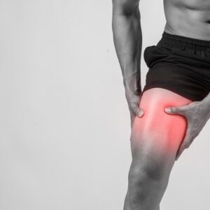 young sport man with strong athletic legs holding knee with his hands pain after suffering ligament injury isolated white