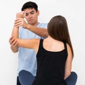 physiotherapist doing elbow exercises with female patient