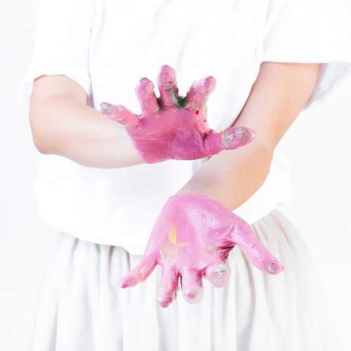 close up female s hand gesturing with pink paint