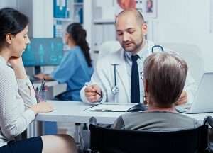 woman wheelchair with her daughter annual doctor appointment selective focus dsabled disability handicapped old person treatment modern private hospital clinic medicine health care